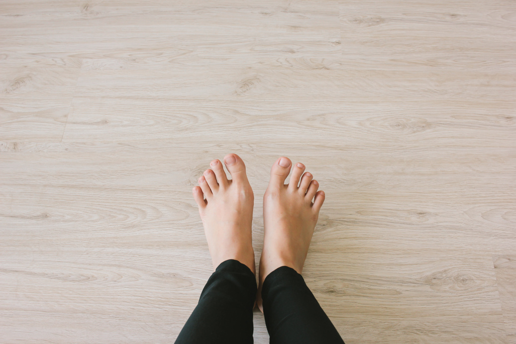 Female Bare Feet on Wooden Floor